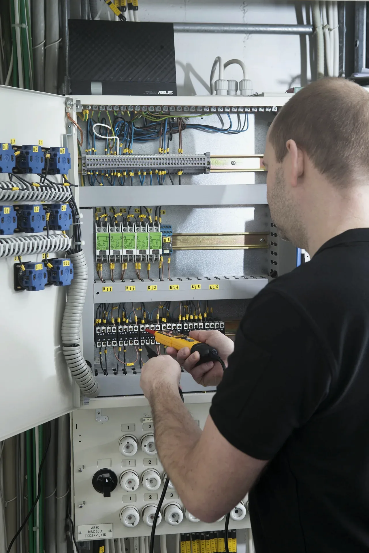 Elektriker arbetar i ett elskåp